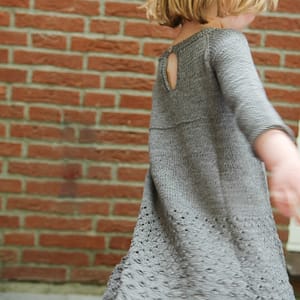 Graues Mädchenkleid mit Durchbruchmustern im Rock