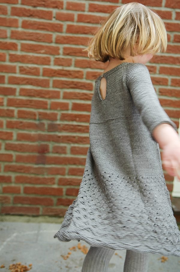 Graues Mädchenkleid mit Durchbruchmustern im Rock
